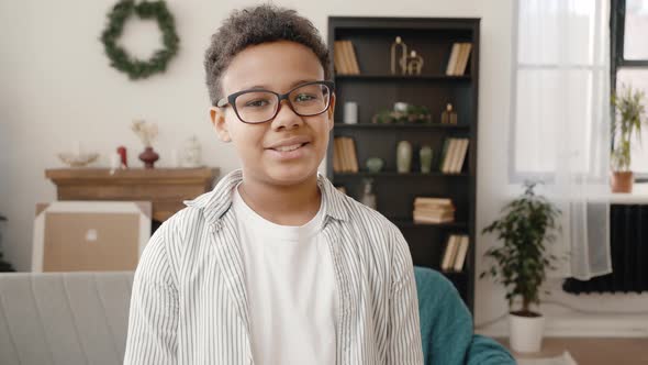 Cute African American Boy Wearing Eyeglasses Smiling to Camera Posing at Home with Christmas Tree alt