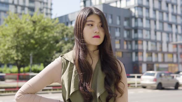 Young Asian Woman Thinks About Something As She Waits Street Urban Area