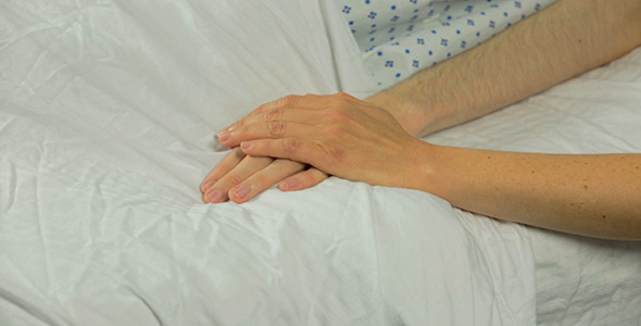 Woman Pats Male Hospital Patient's Hand Twice