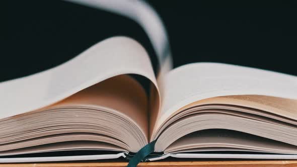 The Pages of the Open Book are Turning on Their Own in Slow Motion CloseUp alt
