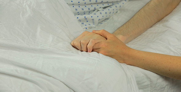 Woman Placing Her Hand Under Male Patient's Hand