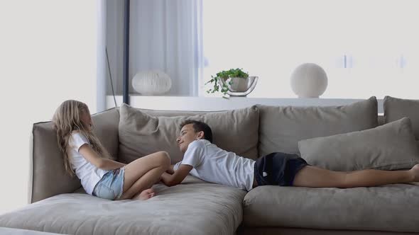 Boy Reading a Book for His Sister at Home