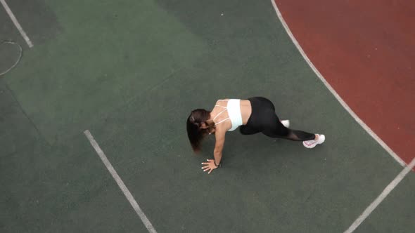 Young Woman Is Doing Plank Exersice Flexing Legs in Dynamic on Sport Ground alt