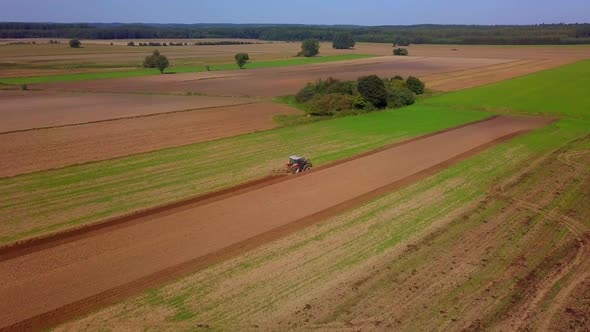 Tractor Working on Field at Autumn alt