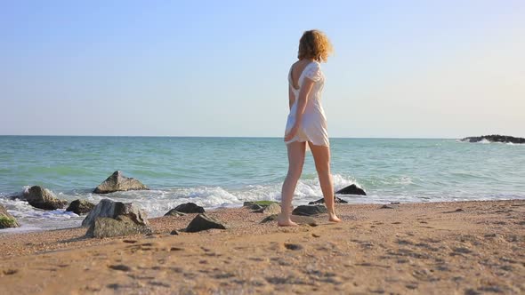 Young Beautiful Woman Walking at the Ocean Beach alt