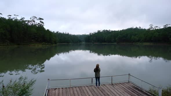 Slow motion of a female traveler looking at a beautiful views by the lake