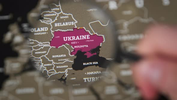 Ukraine on the World Map Under Magnifying Glass alt