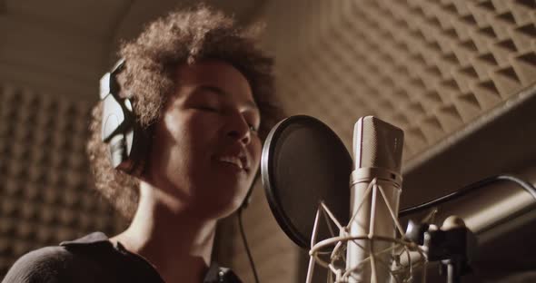 Happy Black Woman Singing Into Microphone alt