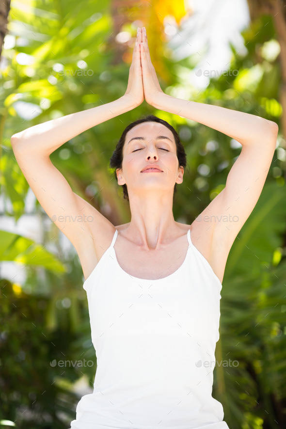 Portrait of a woman in a meditation position against a white background - Stock Photo - Images