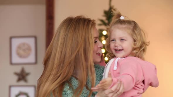 Mom with Daughter in Arms at Christmas