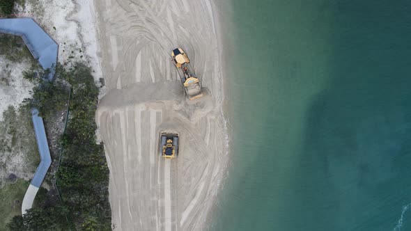 High drone view of large machinery working on a coastal rejuvenation project replenishing sand close alt