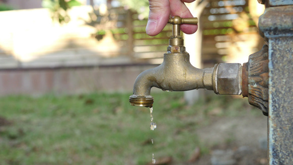 Man Opening and Closing an Old Fashioned Fountain Tap alt