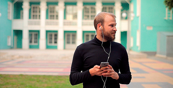 Man Listening to Music with Headphones in a Park
