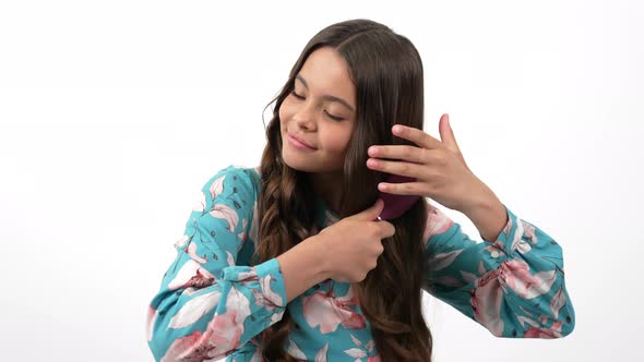 Healthy Smooth Hair of Smiling Child Brushing Them with Comb Showing Thumb Up Haircare