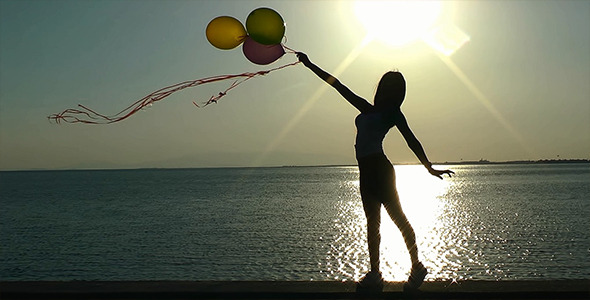 Girl Playing with Ballons at Seaside