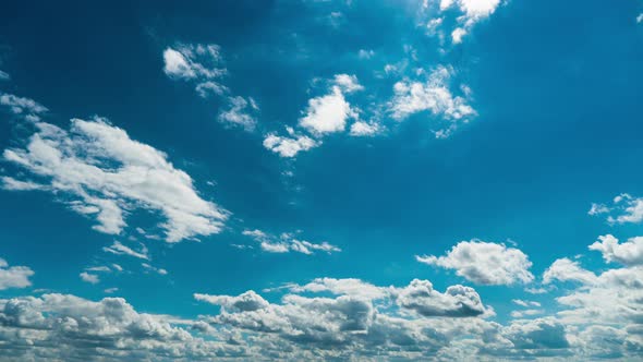White Fluffy Clouds Slowly Float Through the Blue Daytime Sky Timelapse alt
