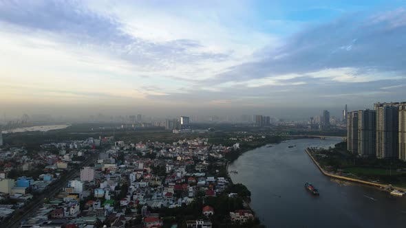 Aerial view overlooking industrial ferries on the Saigon river, in Ho chi minh, Vietnam - circling, alt