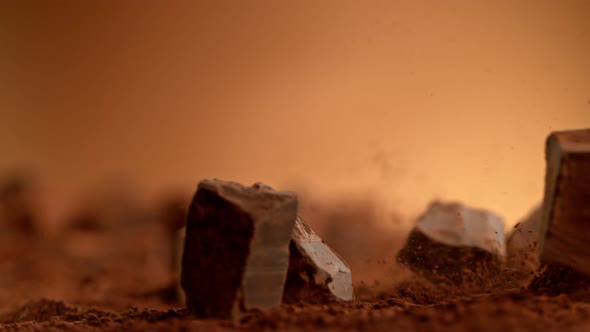 Super Slow Motion Shot of Raw Chocolate Chunks Falling Into Cocoa Powder at 1000Fps alt