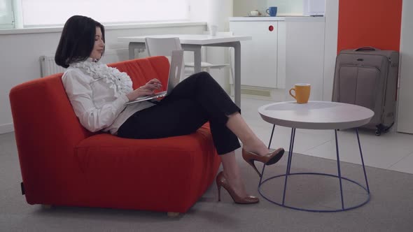 Brunette Computing on Pc in Flat with White Interior alt