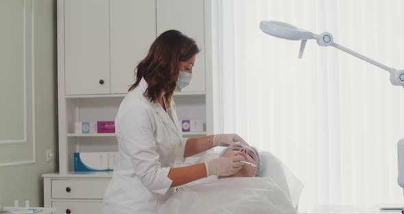 A Cosmetologist Makes an Injection of a Patient Face with Medical Preparations alt