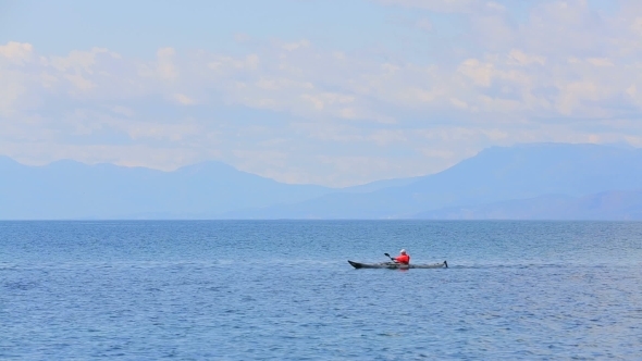 Man Rowing In Canoe In The Sea