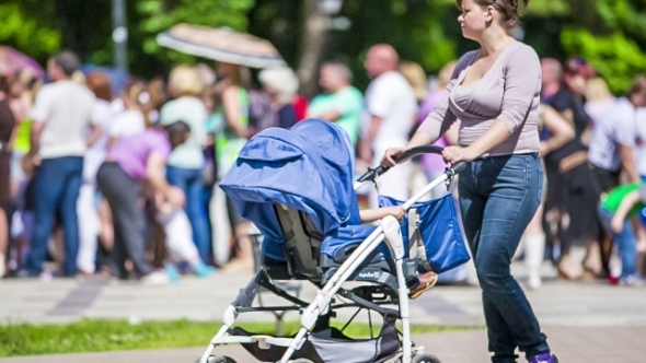 Mother Walking With Baby With In The Stroller
