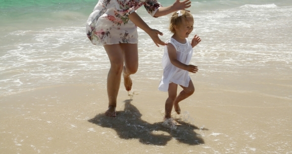 Little Girl Running Along a Beach With Her Mother alt