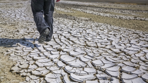 Mans Feet On Cracked Desert Earth