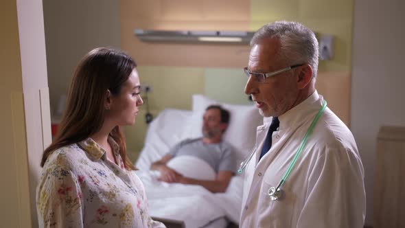 Aging Doctor Telling Bad News To Patient's Wife alt