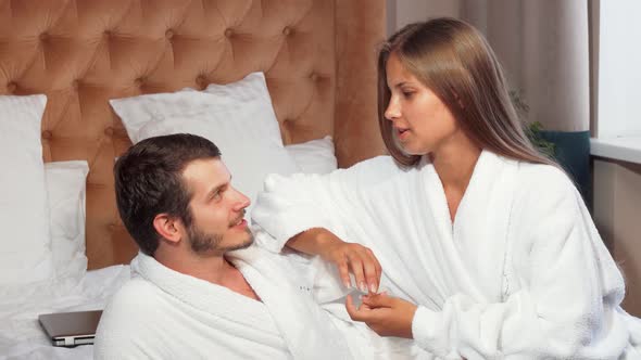 Beautiful Couple Relaxing Together in Bed, Wearing Bathrobes alt