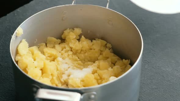  Woman's Hand Making Mashed Potato, Adding Butter and Salt and Mix. Cooking Mashed Potatoes.