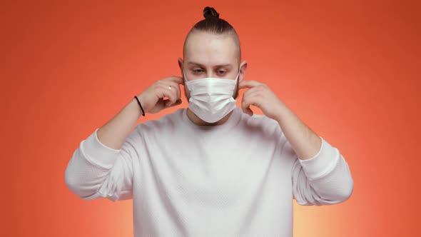 Happy Bearded Man Takes Off Medical Mask Makes Deep Breath on Red Background