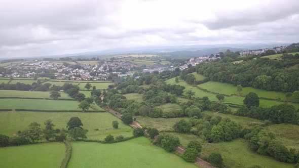 low hanging mist fades over the town of Launceston, cornwall, aerial establishing shot alt