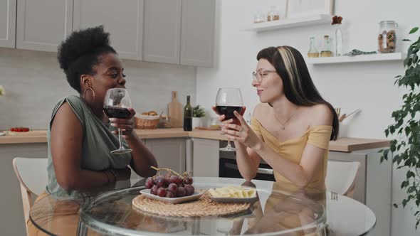 Happy Female Couple Chatting and Enjoying Wine alt