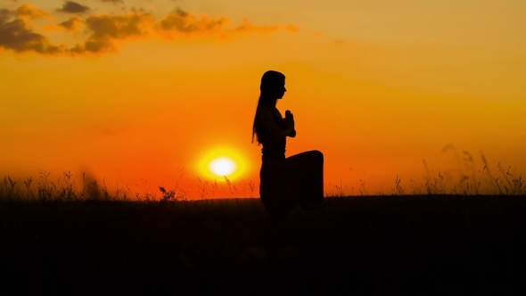 Silhouette Of a Young Girl Practicing Yoga  At