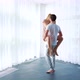 Young Man Holds Woman in his Arms and Spins Around in Spacious Room - VideoHive Item for Sale