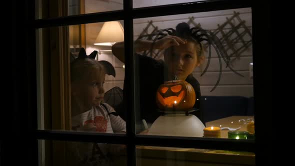 Children, Sisters at Halloween Night Looking Through Window