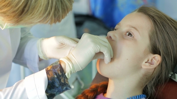 Dentist Applying Staples In Girl Mouth