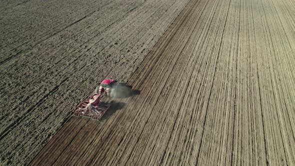 Unmanned Tractor Controlled Remotely Working on Arable Land alt