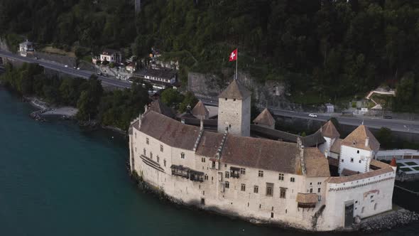 Aerial shows Chillon castle in the evening close from Lausanne, Switzerland alt
