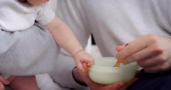 Charming Baby Girl is Fed with a Spoon of Healthy Vegetable Puree
