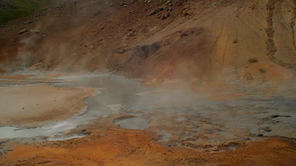 dramatic iceland landscape, geothermal hot spring steam smoke rising from the pools of hot water