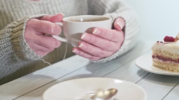 The woman hands holding hot cup of tea. Hot tea in the hands close-up. alt