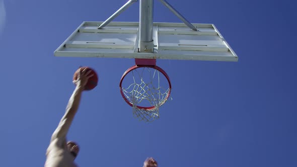 Low angle slow motion shot of man making basketball layup