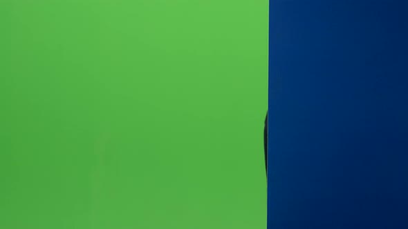 Child Boy in Glasses Peeps Out From the Blue Wall on a Green Screen alt