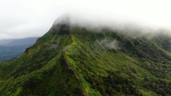 Drone rising above a Hawaiian mountain on east oahu flying into clouds alt