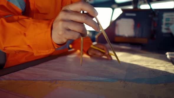 Filipino Deck Officer on Bridge of Vessel or Ship. He Is Plotting Position on Chart alt