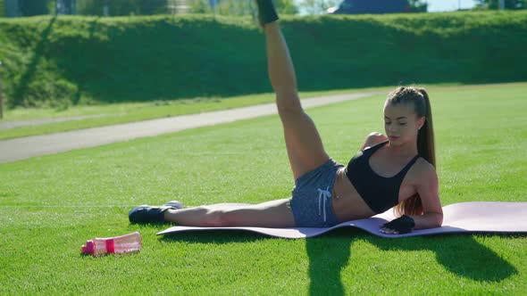 Woman Raising Leg Up on Grass alt