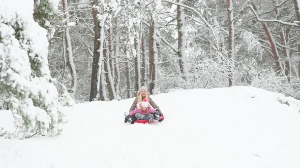 Happy mom plays with her daughter in a winter park