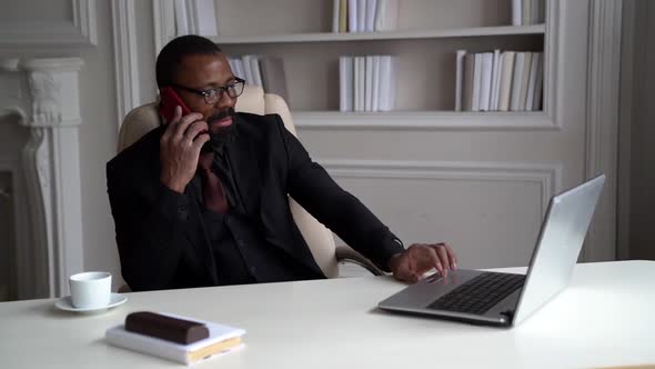 Confident Black Man Is Dressed Business Suit, Talking By Cell Phone in His Home Office alt